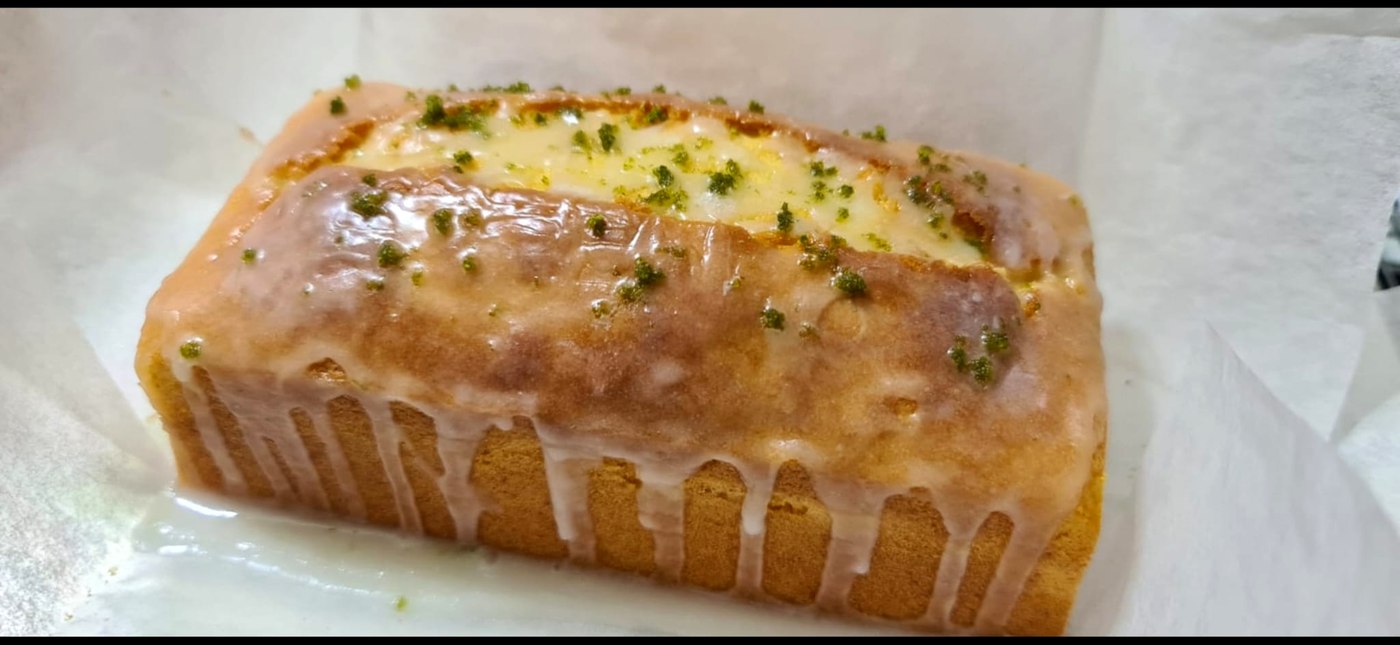 A lemon pound cake baked by Carol, glazed and topped with lemon zest