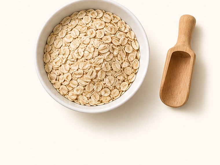 A bowl of rolled oats with a wooden scoop