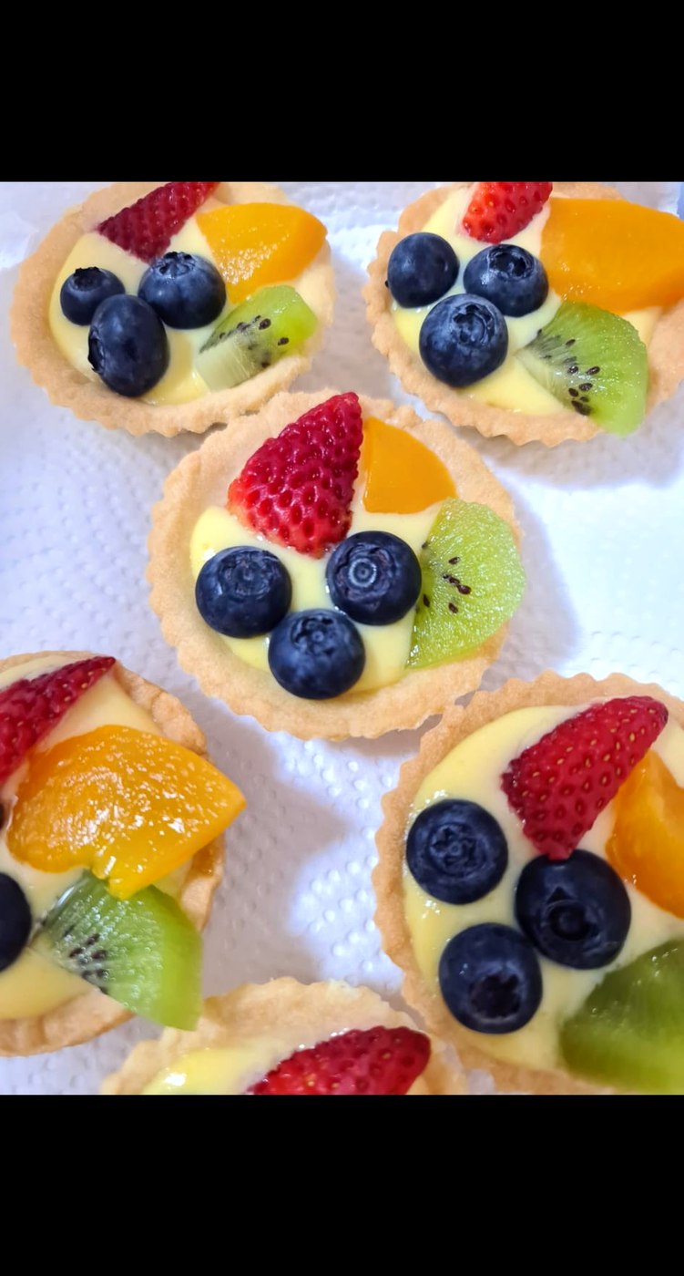 Fruit tarts baked by Carol, topped with strawberries, blueberries, kiwi and mandarin on vanilla custard